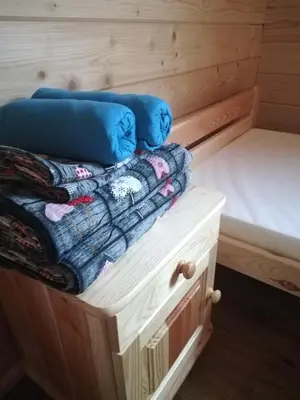 a bed and pillows sitting on top of a wooden cabin at Dom Słoneczna Chata Kasina Wielka in Kasina Wielka