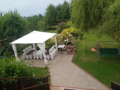 a backyard with a table and chairs and an umbrella at Studio Familly-nocleg-Zator- Wadowice-Oświęcim-Kraków in Bachowice