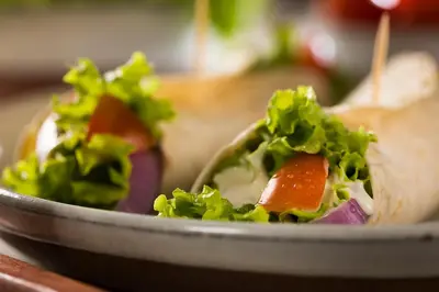 a sandwich on a plate with lettuce and carrots at Unique studio perfect for couples, Old Podgórze in Kraków