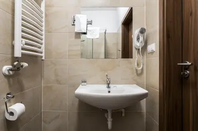 a bathroom with a sink and a mirror at G12 Aparthotel in Kraków