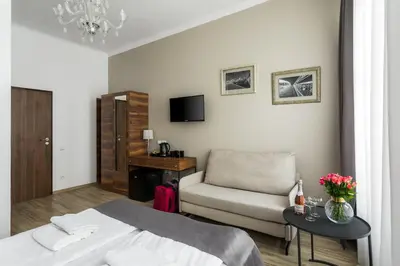 a bedroom with a bed and a chair and a table at G12 Aparthotel in Kraków