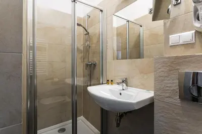 a bathroom with a sink and a shower at G12 Aparthotel in Kraków