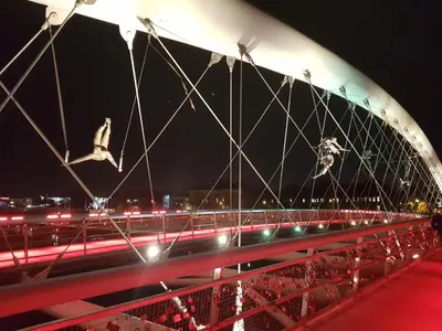 a bridge with birds flying over a highway at night at Cracowapart Ignacio A in Kraków