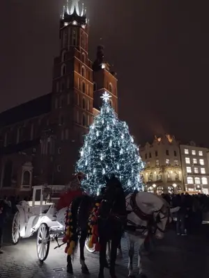 a horse drawn carriage in front of a christmas tree at Cracowapart Ignacio A in Kraków