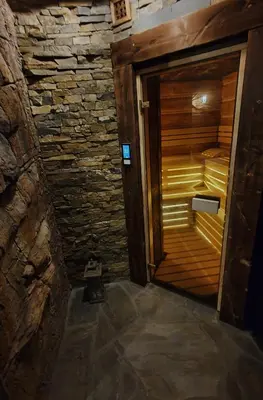 an empty sauna with a wooden door in a room at Domek Hobbita z jaskinią SPA - Osada Jaworzyny in Tokarnia