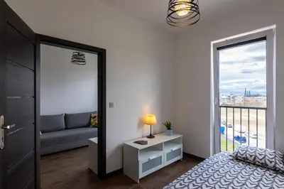 a bedroom with a bed and a window with a couch at ENERGYLANDIA Zator Apartament Grześ in Zator