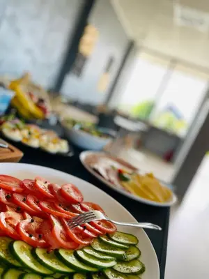 a table topped with plates of food with tomatoes and cucumbers at Kalimera 18 by Housine in Zator