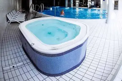 a jacuzzi tub sitting next to a swimming pool at Premium Apartment for Jewish Quarter & Old Town plus Pool in Kraków