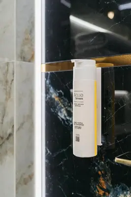 a bottle of sunscreen sitting on a counter in a bathroom at Native Apartments Nowowiejska 9 in Kraków