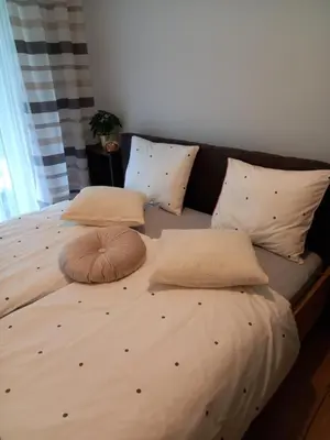 a large bed with two pillows on top of it at Apartament przy Obozie in Oświęcim