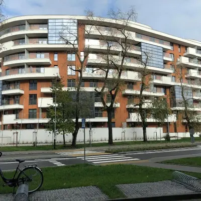 a bike parked in front of a large building at Wiślane Tarasy 2.0, free parking, private garden in Kraków