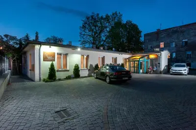 a car parked in a parking lot in front of a building at Red Brick Apartments in Kraków