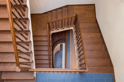 a spiral staircase in a building with a blue tile floor at Cadena Gallery Apartments Wyspiański in Kraków