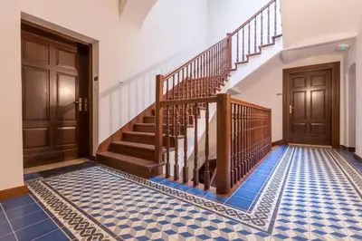 a hallway with stairs and blue tiled floor at Cadena Gallery Apartments Wyspiański in Kraków