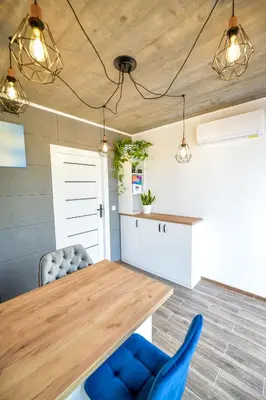 a kitchen with a wooden table and blue chairs at KempingZator in Zator