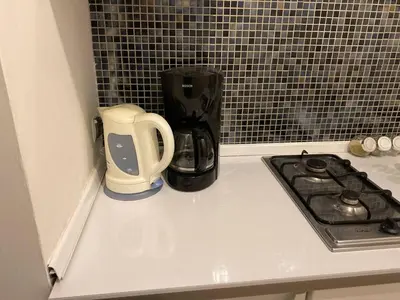 a kitchen counter with a coffee maker and a blender at LOTOS Hostel in Kraków