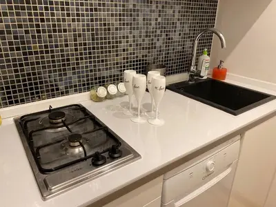 a kitchen counter with a stove and a sink at LOTOS Hostel in Kraków