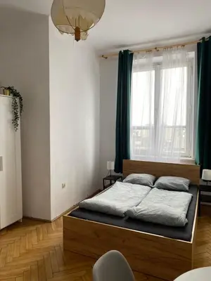 a bedroom with a bed and a large window at Amazing view rooms in Old Town in Kraków