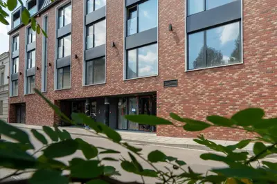 a red brick building with glass windows at Śródmieście Kątowa Air-conditioned Studio Kraków by Noclegi Renters in Kraków