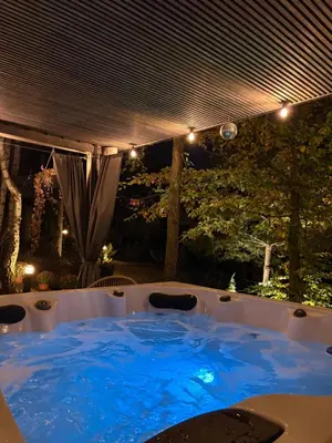 a hot tub with blue water in a backyard at Mucharskie Stodoły Stodoła I - Garden Spa in Jaszczurowa