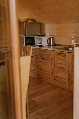 a kitchen with wooden cabinets and a microwave at Apartament Sosnowy Domek Piętro Zator Graboszyce in Graboszyce