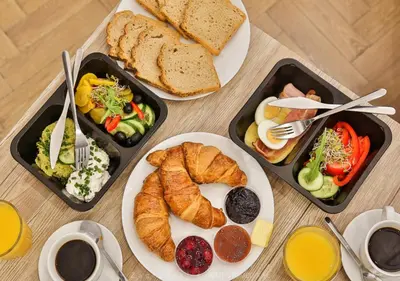 three trays of breakfast food on a table at Premium Splendid Old Town Suites - by Upstairs in Kraków
