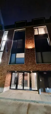 a brick building with windows on a street at night at Apartament Xavier Kraków in Kraków