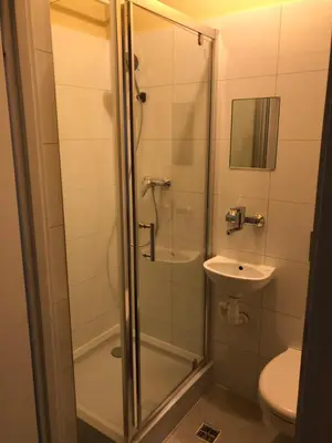 a bathroom with a shower with a sink and a toilet at PIRANIA in Kraków