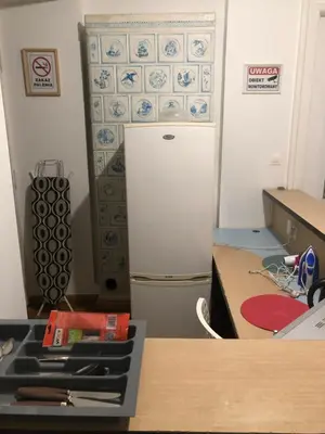 a kitchen with a refrigerator and a table and a counter at PIRANIA in Kraków