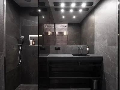 a black bathroom with a sink and a mirror at Art Suites Luxury Hotel in Kraków