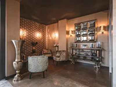 a room with chairs and a table and a shelf at Art Suites Luxury Hotel in Kraków