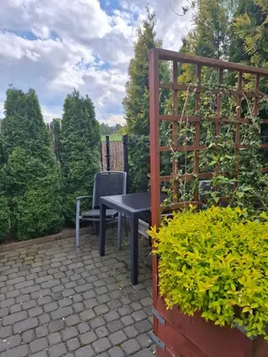 a table and a chair sitting on a patio at Mieszkanie B Łowiczki in Zator
