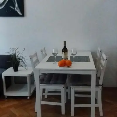 a white table with a bottle of wine and two glasses at Miodowa Kazimierz Apartment in Kraków